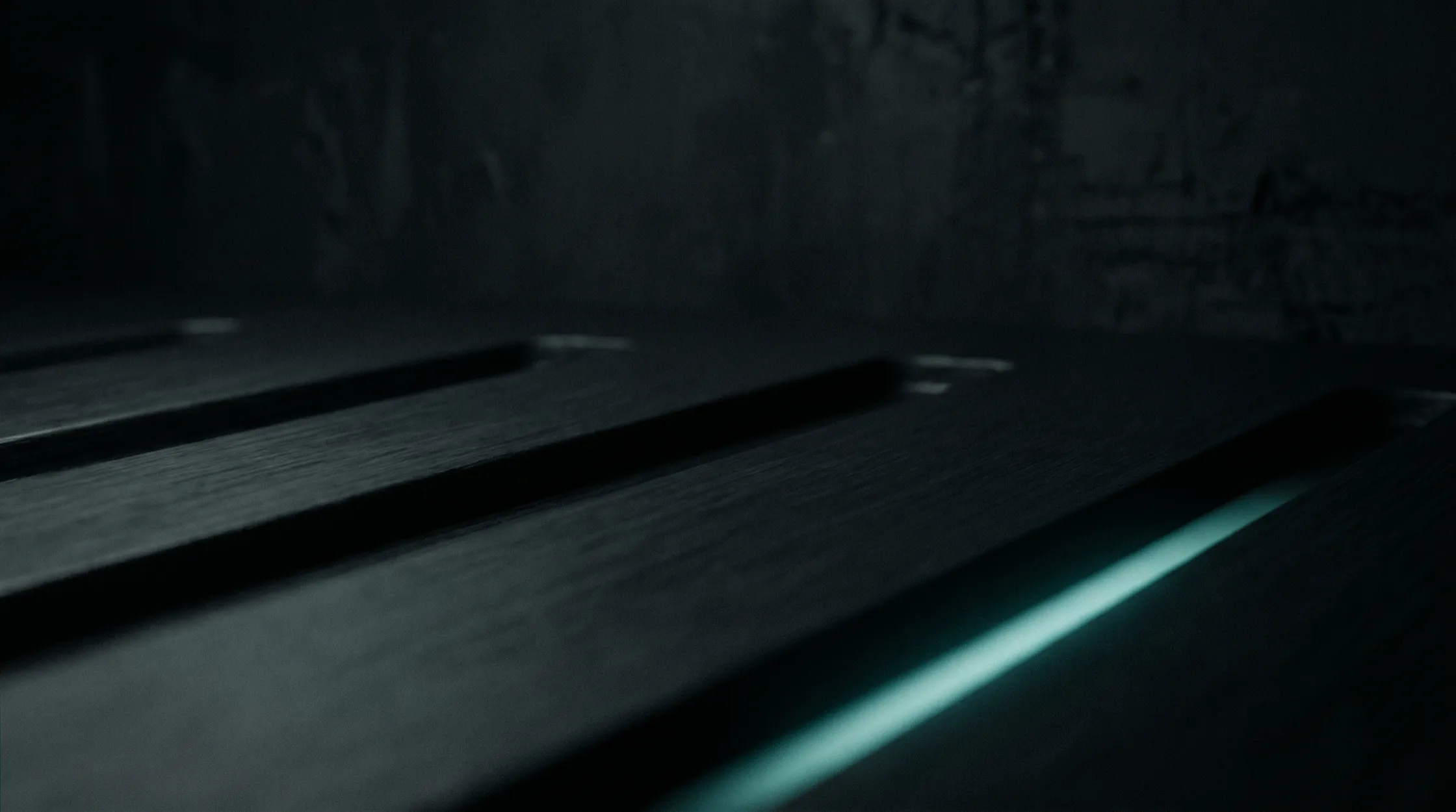 Dark brushed metal surface with a diagonal teal light streak
